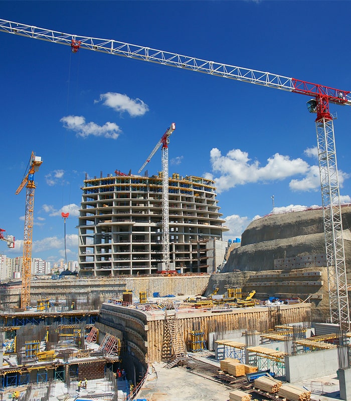 Șantier cu macarale și structură în construcție