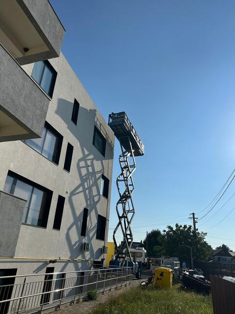Lucrări la fațada unei clădiri cu mai multe etaje